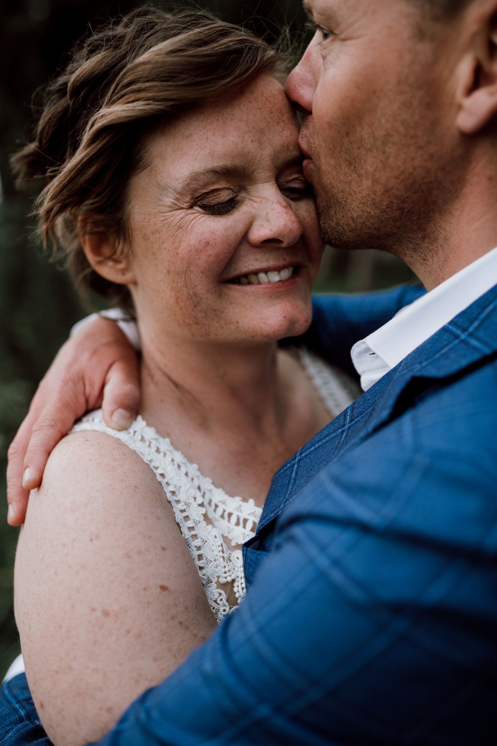 bruidegom kust bruid op voorhoofd tijdens fotoshoot